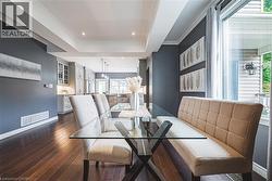 Dining space with dark wood-style flooring, a raised ceiling, crown molding, and recessed lighting - 