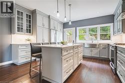 Kitchen featuring decorative backsplash, a kitchen bar, a kitchen island, hanging light fixtures, and recessed lighting - 