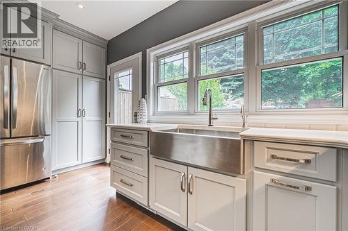 Kitchen with freestanding refrigerator, dark wood finished floors, gray cabinetry, and light stone countertops - 25 Orchard Hill, Hamilton, ON - Indoor Photo Showing Kitchen