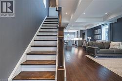 Stairs featuring hardwood / wood-style floors, beam ceiling, coffered ceiling, and recessed lighting - 