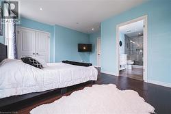 Bedroom featuring wood-type flooring, a closet, connected bathroom, and recessed lighting - 