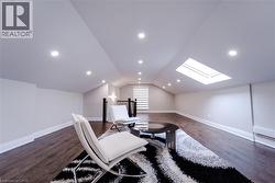 Sitting room with dark hardwood / wood-style flooring and lofted ceiling - 