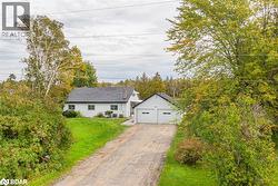 View of front of property featuring an outdoor structure, a front yard, and a garage - 