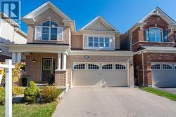 View of front facade with a garage, asphalt driveway, a porch, and brick siding - 