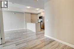 Kitchen with light countertops, appliances with stainless steel finishes, a peninsula, light wood finished floors, and white cabinets - 