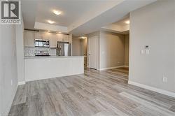 Kitchen with a raised ceiling, stainless steel appliances, open floor plan, light countertops, and light wood-style flooring - 