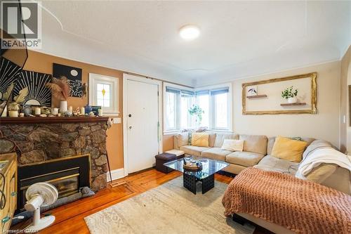 Living area with wood finished floors and a stone fireplace - 41 Paradise Road S, Hamilton, ON - Indoor Photo Showing Living Room With Fireplace