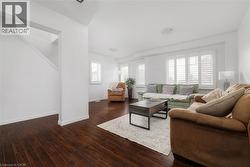 Living room with dark wood-type flooring and baseboards - 