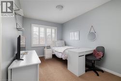 Bedroom with light colored carpet and a desk - 