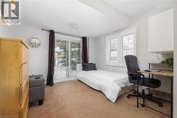 Bedroom with light colored carpet and an office area - 