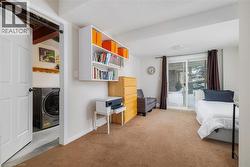 Bedroom with washer / clothes dryer, access to outside, and light colored carpet - 