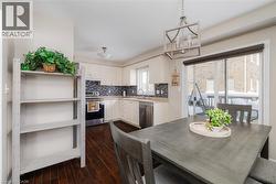 Dining space with dark wood-style flooring and a chandelier - 