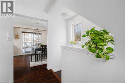 Corridor featuring dark wood-style flooring and a chandelier - 