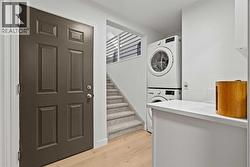 LAUNDRY AREA - OFF THE DOOR THAT LEADS TO THE GARAGE .  STAIRS LEAD TO THE LOFT AREA - 