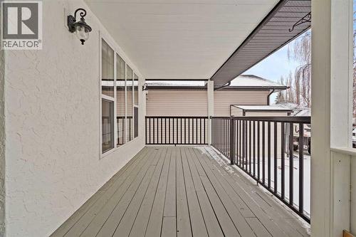 REAR VERANDAH - OVERLOOKS THE PRIVATE AND QUIET REAR YARD - BACKS TO THE ROADWAY - THIS HOUSE IS IN THE SCHOOL ZONE OF 30 KM AN HOUR AND MAX 50 KM OUTSIDE OF SCHOOL TIMES.  THIS IS NOT A BUSY ROAD - 140 Allen Crescent, Vulcan, AB - Outdoor With Deck Patio Veranda With Exterior