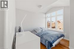 Bedroom featuring hardwood / wood-style floors and lofted ceiling - 