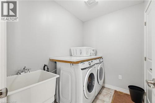 Laundry area with independent washer and dryer and light tile patterned flooring - 23 Doon Creek Street, Kitchener, ON - Indoor Photo Showing Laundry Room