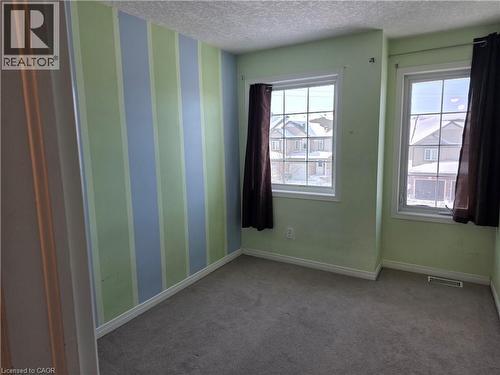 Empty room featuring carpet, a textured ceiling, and wallpapered walls - 220 Snowdrop Crescent, Kitchener, ON - Indoor Photo Showing Other Room