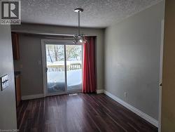Unfurnished dining area with dark wood finished floors and a textured ceiling - 