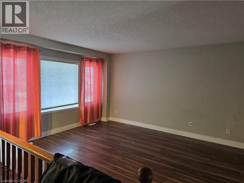 Spare room with a textured ceiling and dark wood-style floors - 220 Snowdrop Crescent, Kitchener, ON - Indoor Photo Showing Other Room