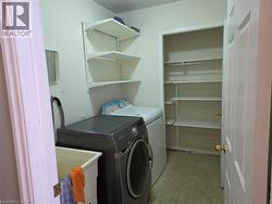 Laundry area featuring light floors and washer and clothes dryer - 