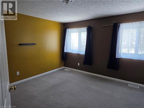 Spare room featuring a textured ceiling and carpet - 220 Snowdrop Crescent, Kitchener, ON - Indoor