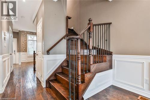 Stairway with wainscoting, hardwood / wood-style floors, crown molding, and a decorative wall - 42 Madonna Drive, Hamilton, ON - Indoor Photo Showing Other Room
