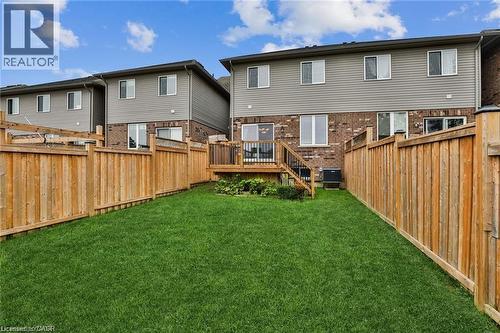 Back of house featuring a fenced backyard, brick siding, a deck, and a residential view - 42 Madonna Drive, Hamilton, ON - Outdoor With Deck Patio Veranda With Exterior
