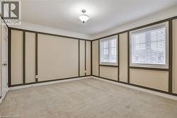 Empty room featuring light colored carpet, crown molding, and a decorative wall - 