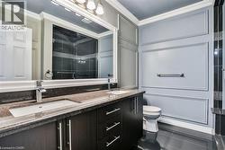 Bathroom with a shower stall, ornamental molding, double vanity, and dark tile patterned flooring - 