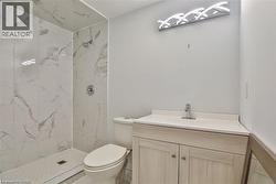 Bathroom featuring vanity and a marble finish shower - 