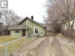 standing on the sidewalk looking down the driveway, which leads to the rear parking area. - 