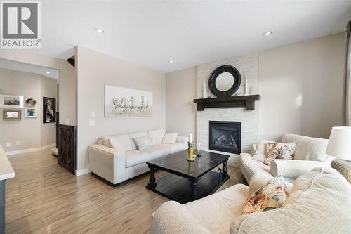 8 Emberside Glen, Cochrane, AB - Indoor Photo Showing Living Room With Fireplace