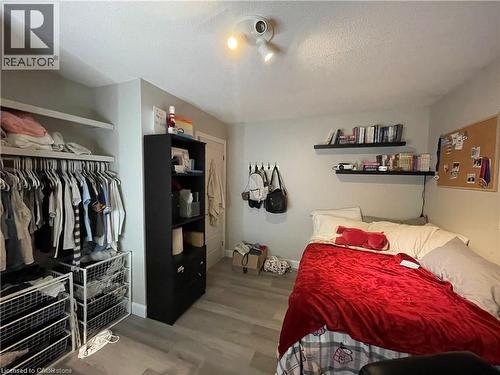 Bedroom featuring wood finished floors, a textured ceiling, and a closet - 18 Rosewell Street, Hamilton, ON - Indoor Photo Showing Bedroom