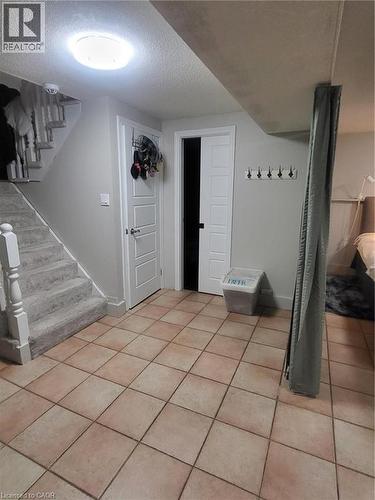 This family room, originally intended as a shared living space, is currently used as a bedroom and home office. It features a fireplace, adding warmth and character to the versatile layout, which comf - 18 Rosewell Street, Hamilton, ON - Indoor Photo Showing Other Room