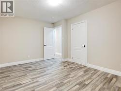 Empty room featuring a textured ceiling and light wood-style floors - 