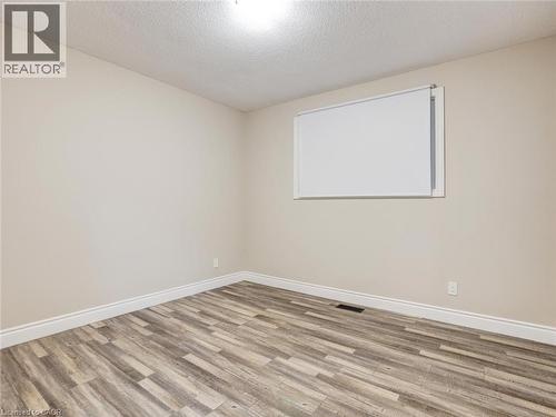 Empty room featuring a textured ceiling and wood finished floors - 55 Silver Aspen Crescent, Kitchener, ON - Indoor Photo Showing Other Room