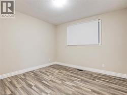 Empty room featuring a textured ceiling and wood finished floors - 