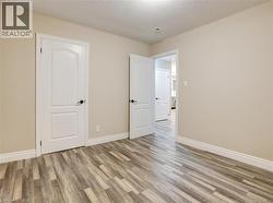 Unfurnished bedroom featuring a textured ceiling and wood finished floors - 