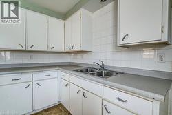 Kitchen featuring white cabinets and tasteful backsplash - 