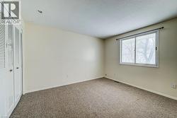Unfurnished bedroom featuring a closet, carpet floors, and a textured ceiling - 