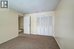 Unfurnished bedroom featuring a textured ceiling, carpet, and a closet - 