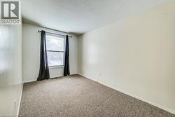 Empty room with light colored carpet and a textured ceiling - 