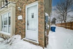 Snow covered property entrance featuring brick siding and stone siding - 