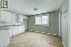 Kitchen with white cabinetry, light countertops, and decorative backsplash - 