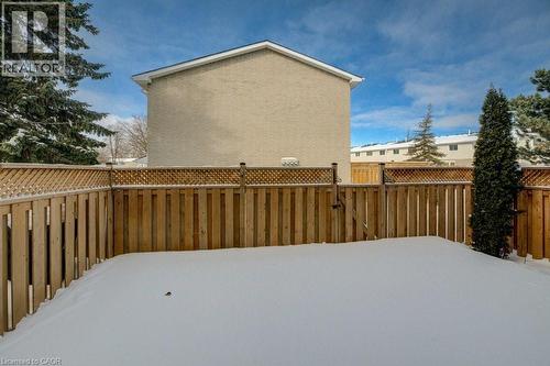 Yard covered in snow featuring a fenced backyard and a gate - 54 Nicklaus Drive, Hamilton, ON - Outdoor With Exterior