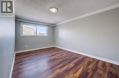 Unfurnished room with dark wood-type flooring, ornamental molding, and a textured ceiling - 54 Nicklaus Drive, Hamilton, ON - Indoor Photo Showing Other Room