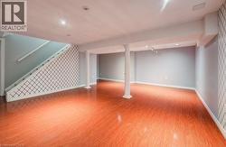 Finished basement featuring light wood-style flooring, an accent wall, recessed lighting, and stairway - 
