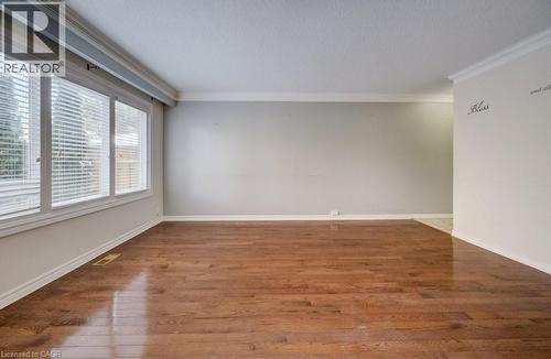 Unfurnished room with crown molding, hardwood / wood-style floors, and a textured ceiling - 54 Nicklaus Drive, Hamilton, ON - Indoor Photo Showing Other Room