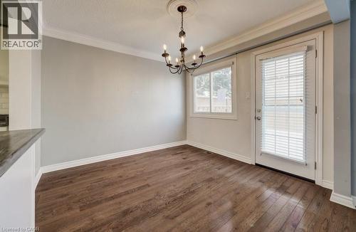 Unfurnished dining area with dark wood-style floors, a chandelier, and crown molding - 54 Nicklaus Drive, Hamilton, ON - Indoor Photo Showing Other Room